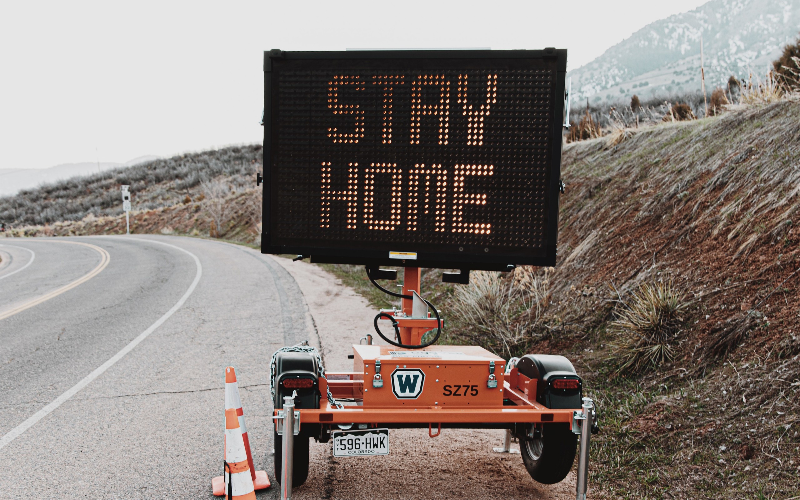 Roadside electronic traffic sign displaying the message "Stay Home"