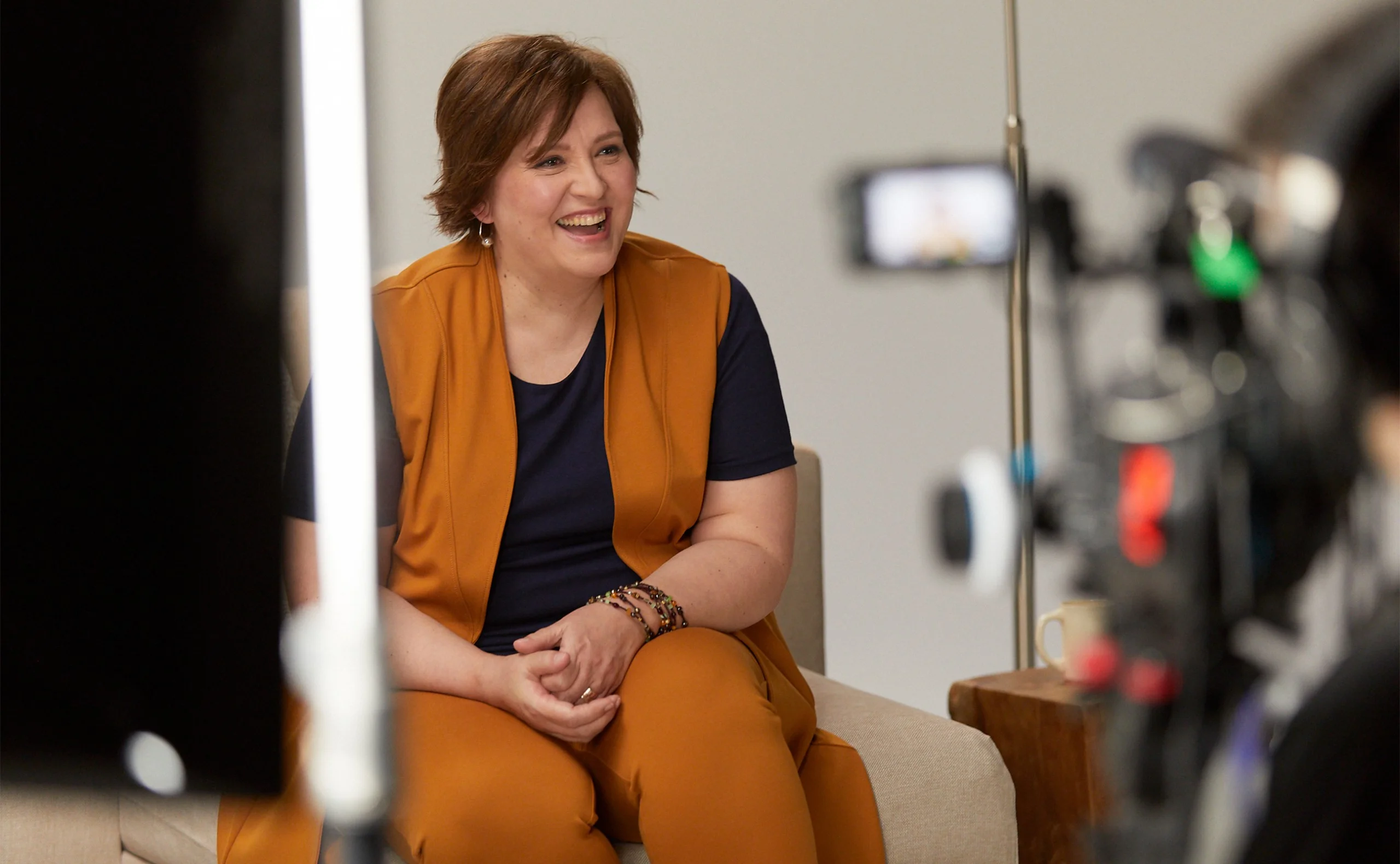 Woman smiling on the set of Anne Mulaire's video set.