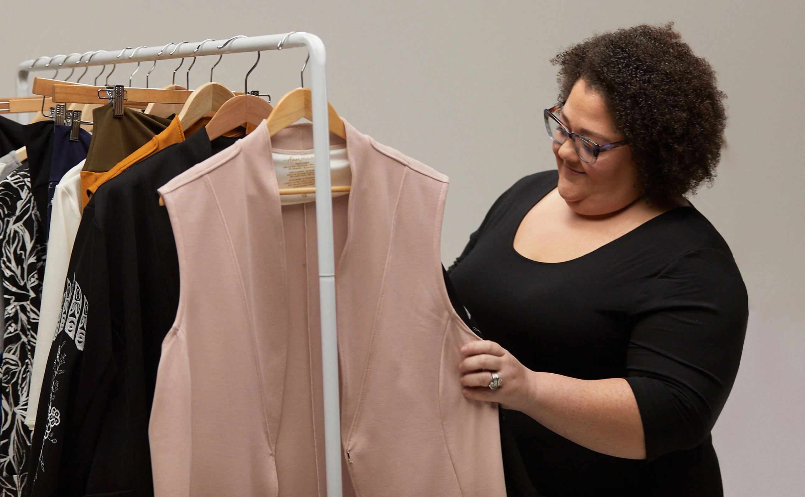 Woman browsing a clothing rack on the set of Anne Mulaire's video shoot.