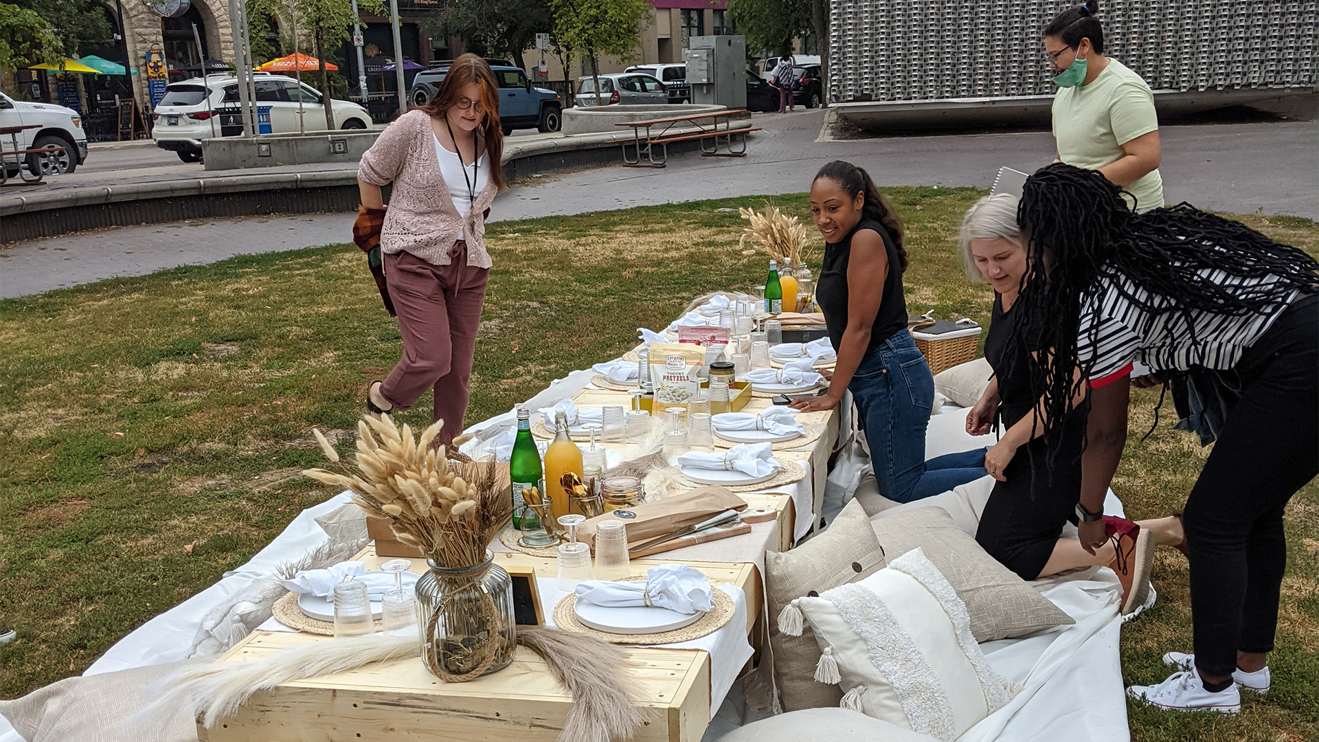 UpHouse staff around a low table outdoors with pillows and place settings