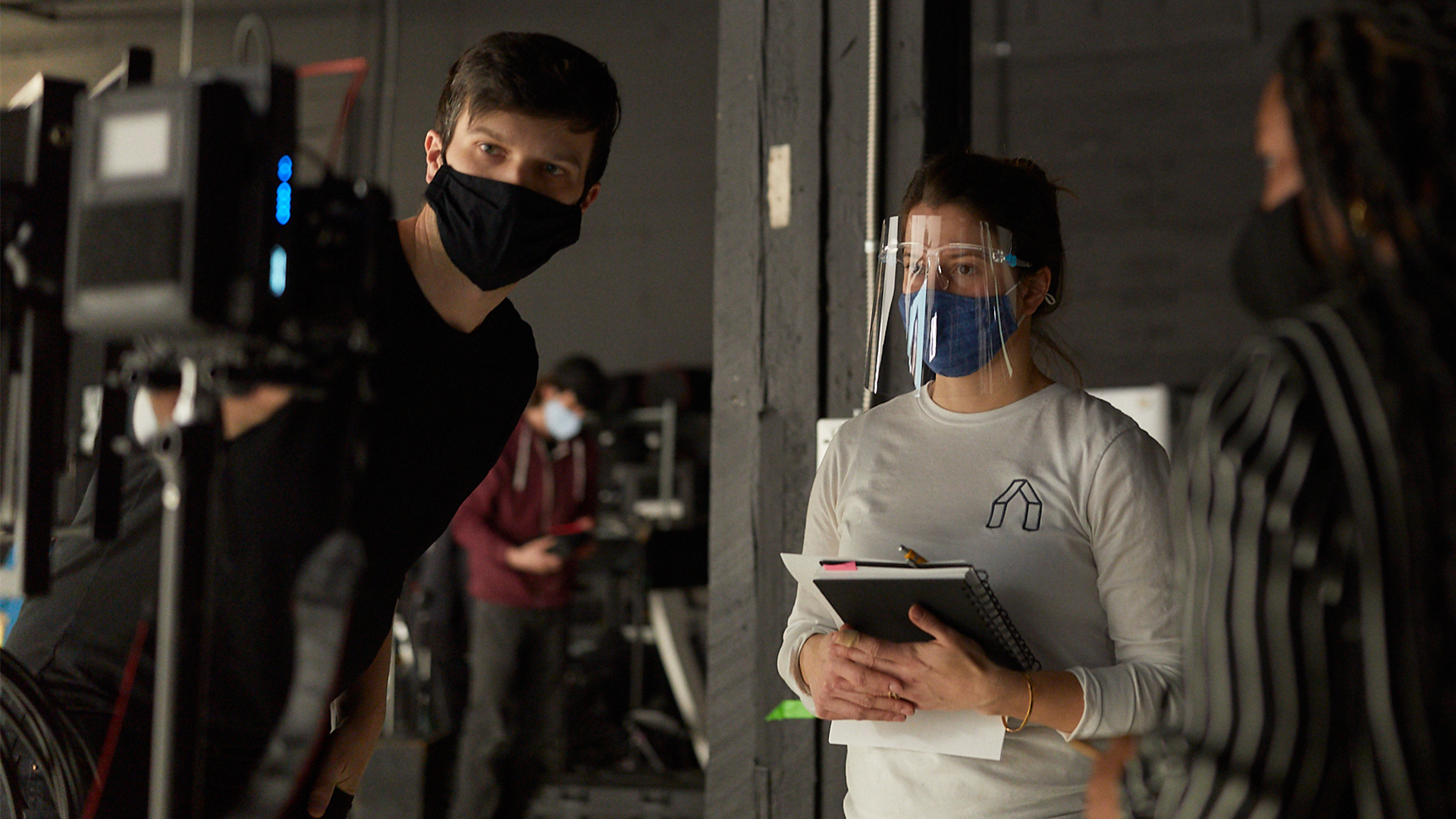 Man and woman looking at a camera screen with masks on