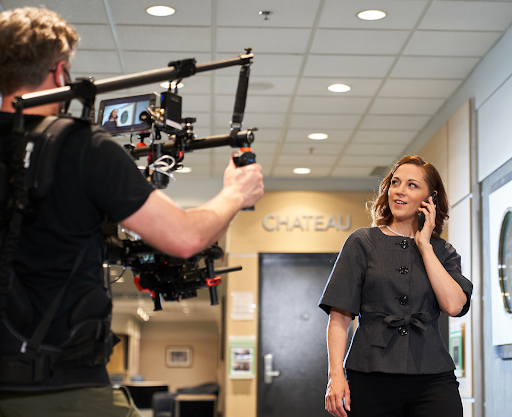 Behind the scenes shot of Manitoba Hotel Association Campaign, with a camera person shooting an individual on their phone.