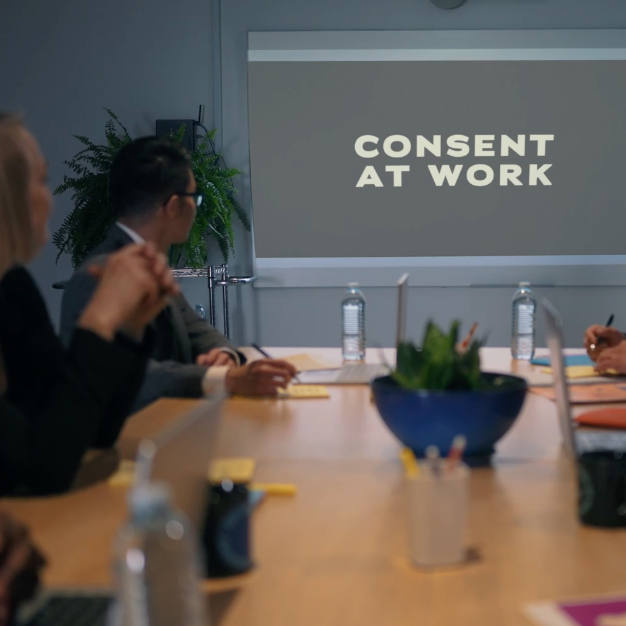 Consent At Work being projected on a screen in a boardroom