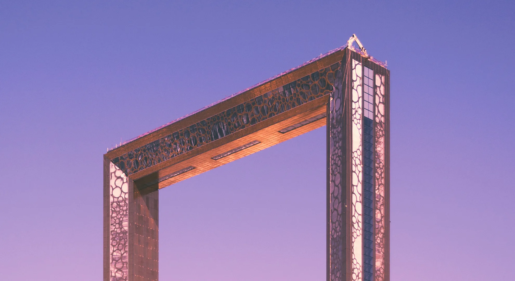 Mosaic archway resembling a frame on a pink and purple gradient sky