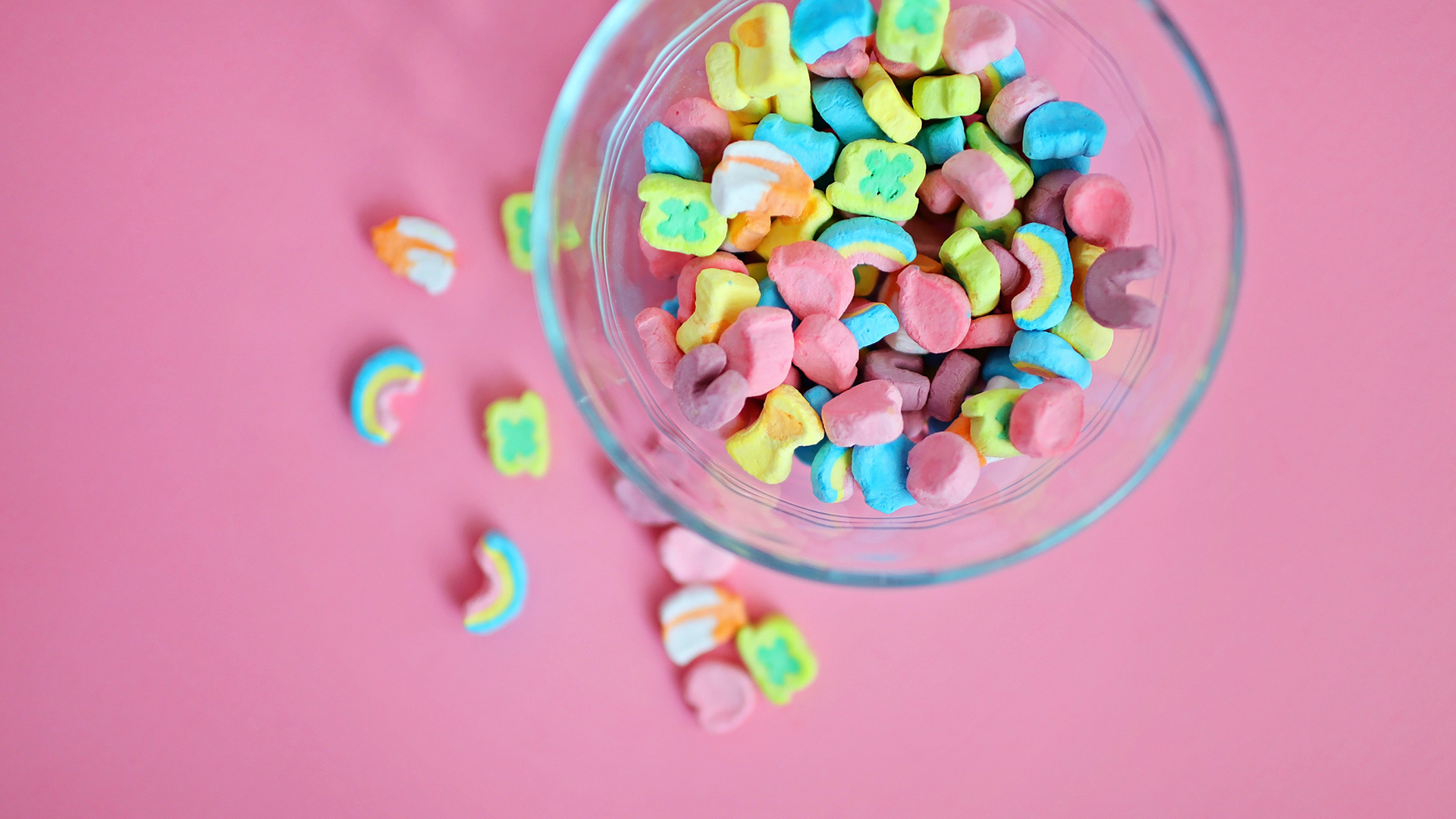 Bowl of Lucky Charms marshmellows on a pink background.
