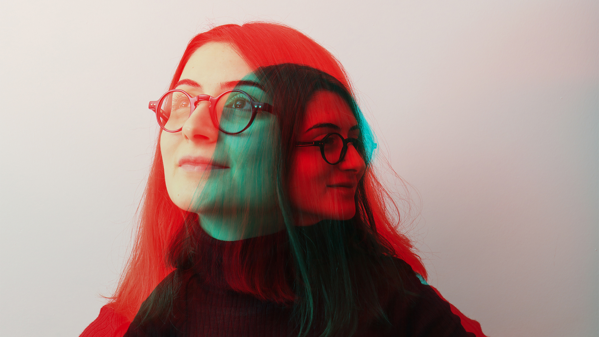 A double exposed image of a woman with glasses with a 3-D effect applied