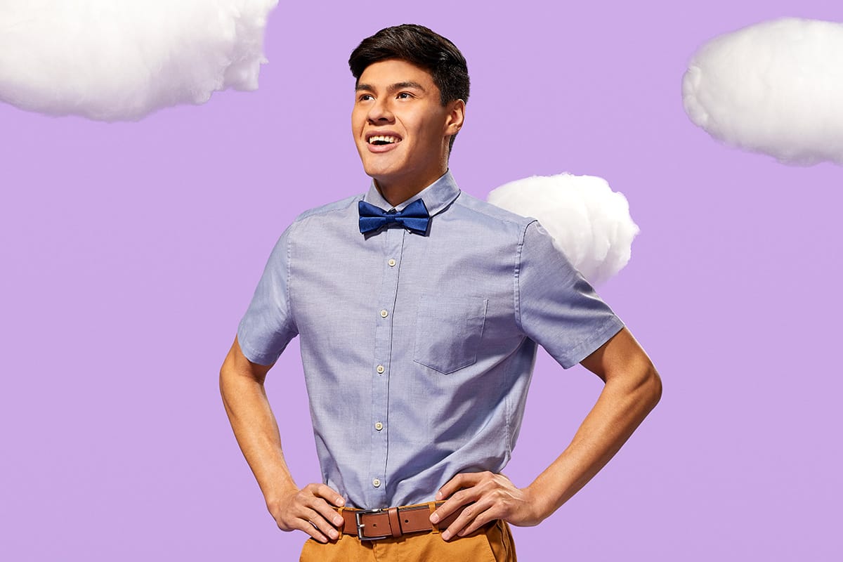 Technation Student standing arms akimbo in front of stylized purple background.