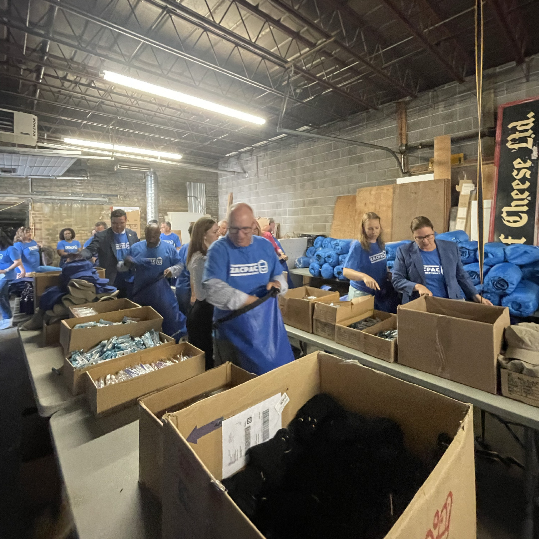 Volunteers filling ZacPac bags in a warehouse space