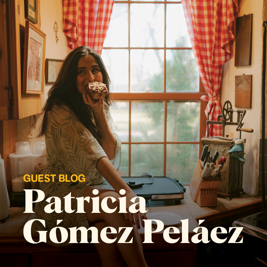 Patricia Gomez sitting on a cozy kitchen counter looking off camera eating a cinnamon bun.