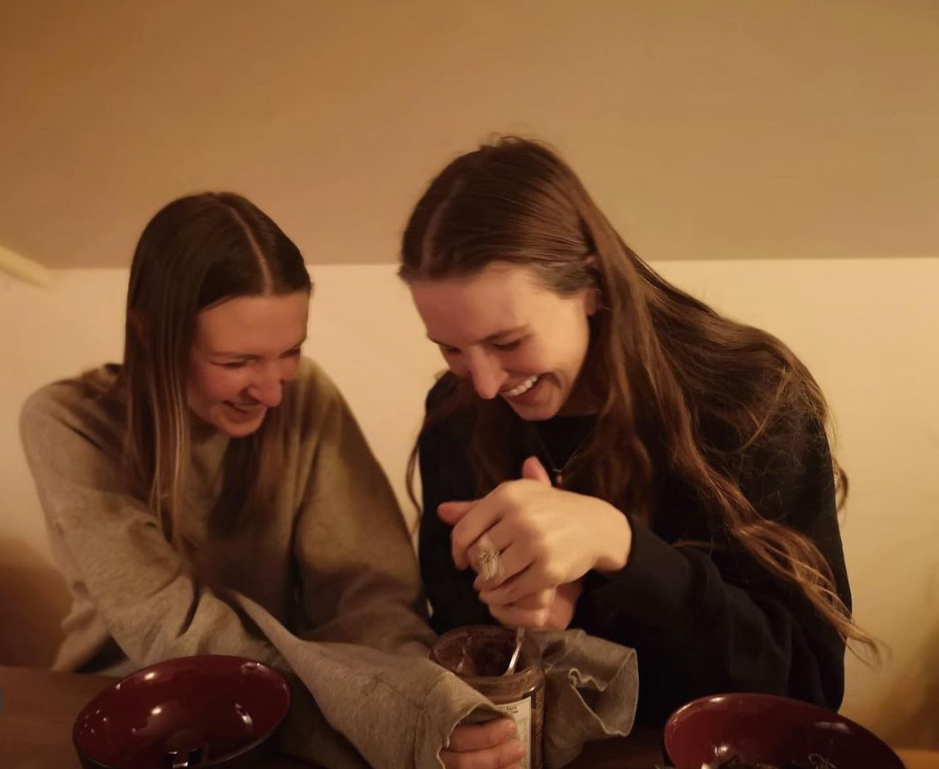 Candid photo of Hayley and Kendra laughing as they bake together.