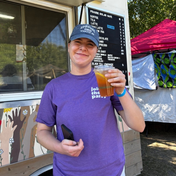 5 Person wearing a purple DrinkSense shirt and holding a drink.