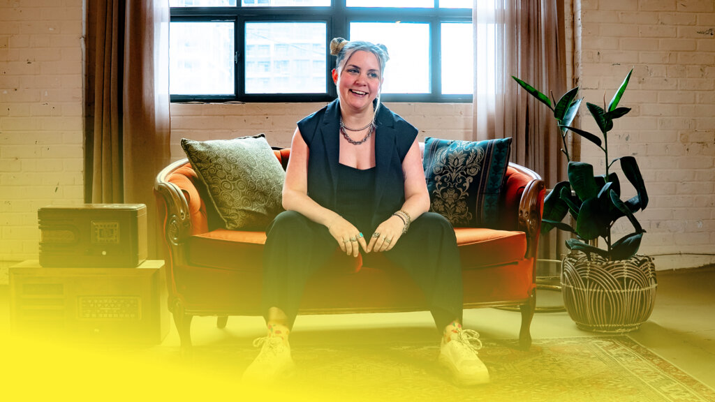 CQCC-Case-Study-Web-Assets Woman sitting on an old couch with a yellow gradient in front of her.