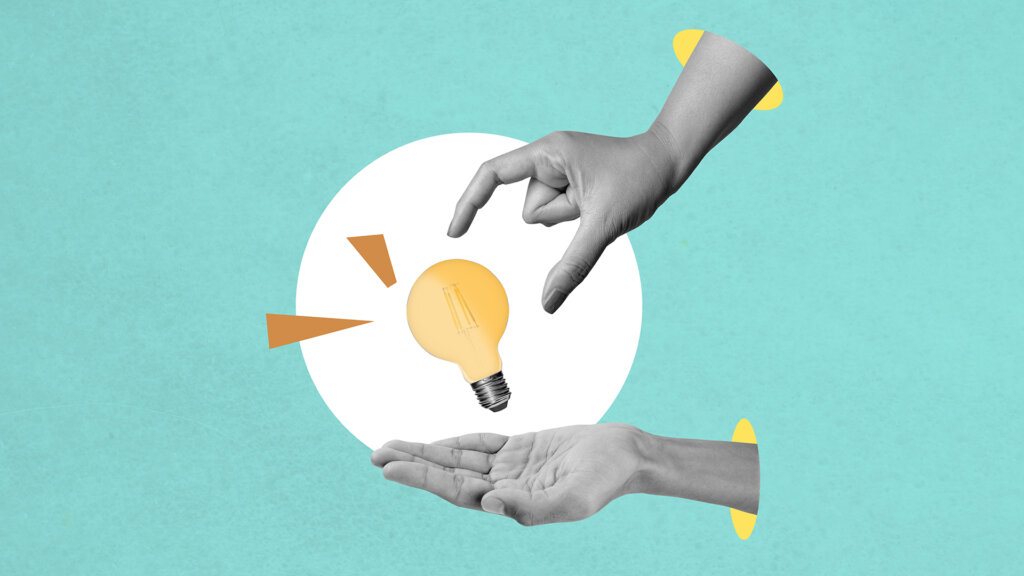 A human hand gives a bright light bulb on a colored background