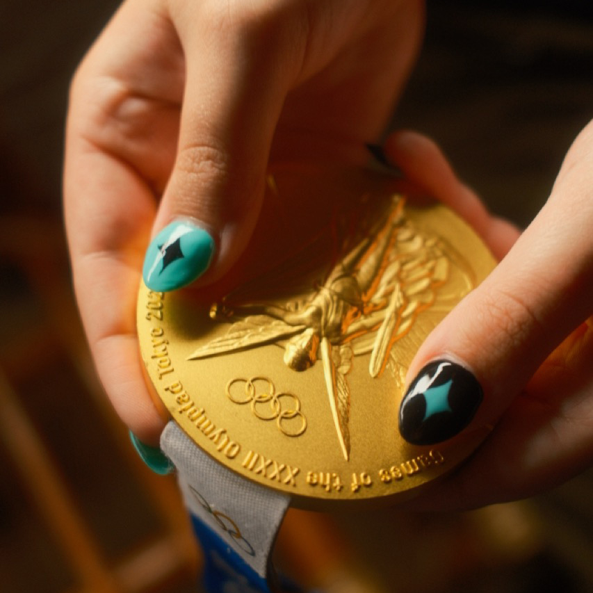 Hands holding a gold medal.